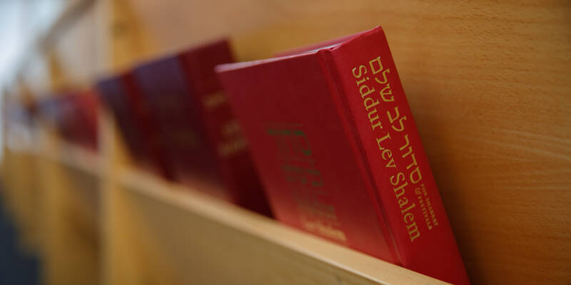 Image of prayer book (Siddur) with red cover in pew